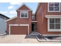 Charming two-story home featuring a garage and covered entryway on a sunny day at 8372 Bijou Creek Ave, Littleton, CO 80125