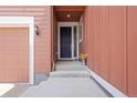 Inviting front entryway with a dark blue door, concrete steps, and exterior lighting at 8372 Bijou Creek Ave, Littleton, CO 80125
