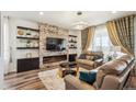 Cozy living room features a stone fireplace, floating shelves, and modern lighting at 9503 Richfield St, Commerce City, CO 80022