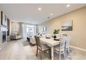 Open-concept living space with dining area flowing into a cozy living room at 8915 Federal Blvd # 203, Denver, CO 80260