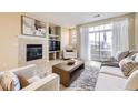 Cozy living room with fireplace, large window, comfortable seating, and access to the patio at 8915 Federal Blvd # 203, Westminster, CO 80260