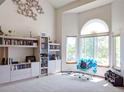 Bright living room featuring a cathedral ceiling, comfortable chair, and natural light from windows at 5695 W 109Th Cir, Westminster, CO 80020
