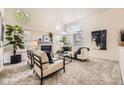 Bright living room features high ceilings, large windows, a cozy fireplace, and modern decor at 5016 S Nelson St # C, Littleton, CO 80127