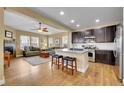 Open concept kitchen and living room featuring stainless steel appliances, center island, and hardwood floors at 10452 Rutledge St, Parker, CO 80134