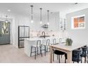 Bright kitchen with island, stainless appliances, modern lighting and white cabinetry at 4640 W 39Th Ave, Denver, CO 80212