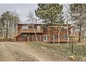 Rustic home with fenced yard, deck, and wooded surroundings provides a serene outdoor living experience at 26167 De Berry St, Conifer, CO 80433