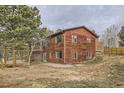 This home offers a rustic exterior with a wooden deck and surrounding natural landscape, perfect for nature lovers at 26167 De Berry St, Conifer, CO 80433
