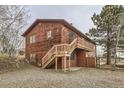 This is a rustic home featuring a wooden exterior, a staircase leading to the upper level, and a natural landscape at 26167 De Berry St, Conifer, CO 80433