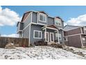 Stylish two-story townhome with a blue exterior, white trim, and a red roof, set against a cloudy sky in winter at 711 Elm St, Frederick, CO 80530