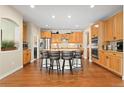 Spacious kitchen with wood cabinets, granite countertops, and a large island with seating at 507 Ulster Way, Denver, CO 80230