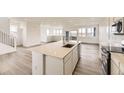 Open kitchen with large center island, stainless steel appliances, and ample natural light at 8866 Waterleaf Ln, Littleton, CO 80125