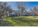 Beautiful landscaped front yard with mature trees and lush green grass showcasing the home's exterior at 4401 S Yosemite Ct, Greenwood Village, CO 80111