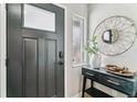 Modern entryway featuring a dark door with glass pane, decor, and console table at 13586 W Warren Cir, Lakewood, CO 80228