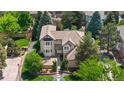 An aerial view of a two-story home with a well-maintained lawn and mature trees at 9232 Rockport Ln, Highlands Ranch, CO 80126