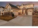 Inviting home with stone detailing, a three-car garage, and a beautifully paved driveway at 10100 Isle St, Parker, CO 80134