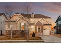 Charming two-story home featuring stone accents, a well-kept lawn, and attached garage at 10100 Isle St, Parker, CO 80134