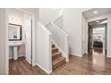 Inviting entryway with a staircase, half-bath, and wood-look floors bathed in soft, natural light at 15246 W 94Th Ave, Arvada, CO 80007