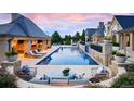 Luxury backyard with large pool, covered outdoor kitchen, lounge chairs, and mature landscaping at 4603 S Denice Dr, Cherry Hills Village, CO 80111