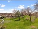 The exterior view features a spacious lawn and landscaping surrounding a well-maintained apartment complex at 12979 W Ohio Ave, Lakewood, CO 80228