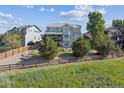 A spacious backyard features a wooden fence, mature trees, and a private setting at 1022 Orion Way, Castle Rock, CO 80108
