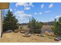 Beautiful backyard featuring mature trees, a firepit, and gravel at 1022 Orion Way, Castle Rock, CO 80108