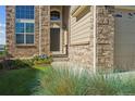 A welcoming front entrance featuring a stone facade, an ADT security sign, and lush landscaping at 1022 Orion Way, Castle Rock, CO 80108