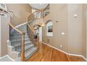 Elegant foyer featuring a curved staircase with iron railings and hardwood floors at 1022 Orion Way, Castle Rock, CO 80108
