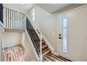 Welcoming entryway with wood stairs and modern black metal railing detail, creating an elegant entrance at 1152 S Salida Way, Aurora, CO 80017