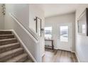 Bright entryway with wood floors, stairs and decorative wall hangings creates a warm welcome at 2409 Alto St, Fort Lupton, CO 80621