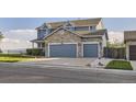 Two-story home featuring a spacious three-car garage with a stone facade at 8915 S Field Ct, Littleton, CO 80128