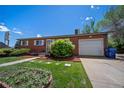 Classic brick home with attached garage, verdant lawn, and tidy landscaping presents a welcoming curb appeal at 12024 W Maryland Dr, Lakewood, CO 80228