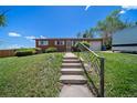 Inviting home featuring a brick facade, front lawn, and convenient stairway leading up to the entrance at 12024 W Maryland Dr, Lakewood, CO 80228