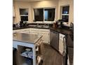 Modern kitchen with stainless steel appliances, dark countertops, and bright white cabinets at 3839 E 135Th Way, Thornton, CO 80241