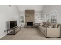 Inviting living room featuring a stone fireplace, vaulted ceiling and built-in shelving at 2101 S Victor St # C, Aurora, CO 80014