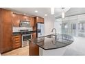 Stylish kitchen with stainless steel appliances, dark granite counters, and wood cabinets at 891 14Th St # 1506, Denver, CO 80202