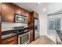 Well-equipped kitchen with stainless appliances, dark granite counters, and wood cabinets at 891 14Th St # 1506, Denver, CO 80202