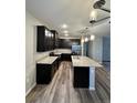 Modern kitchen with an island, dark cabinetry, and granite countertops at 1881 S Dunkirk St # 104, Aurora, CO 80017