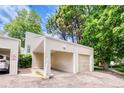 Exterior shot of home showing covered parking space and an attached one-car garage surrounded by mature trees at 1519 S Sable Blvd # C, Aurora, CO 80012