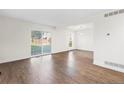 Bright and spacious living room featuring hardwood floors, ample natural light, and a sliding glass door leading to the backyard at 1519 S Sable Blvd # C, Aurora, CO 80012