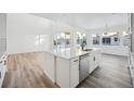 Open concept kitchen island with white cabinets and stainless steel appliances at 3372 N Buchanan Way, Aurora, CO 80019