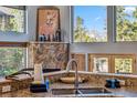 Kitchen sink and granite counters feature with mountain views from large windows and stone fireplace at 180 Emmett Lode Rd, Breckenridge, CO 80424