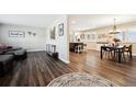 Open-concept living room boasts wood-look flooring, leading to a dining area and creating a seamless flow at 7310 S Sheridan Ct, Littleton, CO 80128