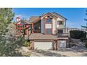 Beautiful two-story home with a brick and white facade, a two-car garage, and a professionally landscaped yard at 15935 W 77Th Pl, Arvada, CO 80007