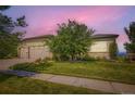 Well-maintained, stucco home with a manicured lawn, mature tree, and a three-car garage at 15975 Quandary Loop, Broomfield, CO 80023