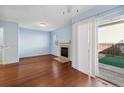 Bright living room with hardwood floors, fireplace, and sliding glass doors to the backyard at 7234 E 38Th Ave, Denver, CO 80207