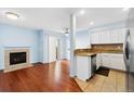 Open-concept living space featuring hardwood floors, a fireplace, and a bright kitchen at 7234 E 38Th Ave, Denver, CO 80207