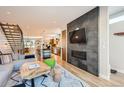 Open-concept living room with a fireplace, hardwood floors, and seamless flow to the kitchen at 3188 W 28Th Ave, Denver, CO 80211