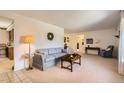 Spacious living room with neutral carpet, traditional furnishings, and open access to kitchen and other rooms at 4056 E Orchard Rd, Centennial, CO 80121