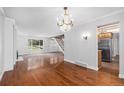 Spacious living room boasts hardwood floors, fireplace and backyard view with elegant chandelier overhead at 3210 S Oneida Way, Denver, CO 80224