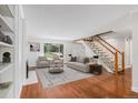 Bright living room featuring hardwood floors, a fireplace, and a staircase leading to the second floor at 3210 S Oneida Way, Denver, CO 80224